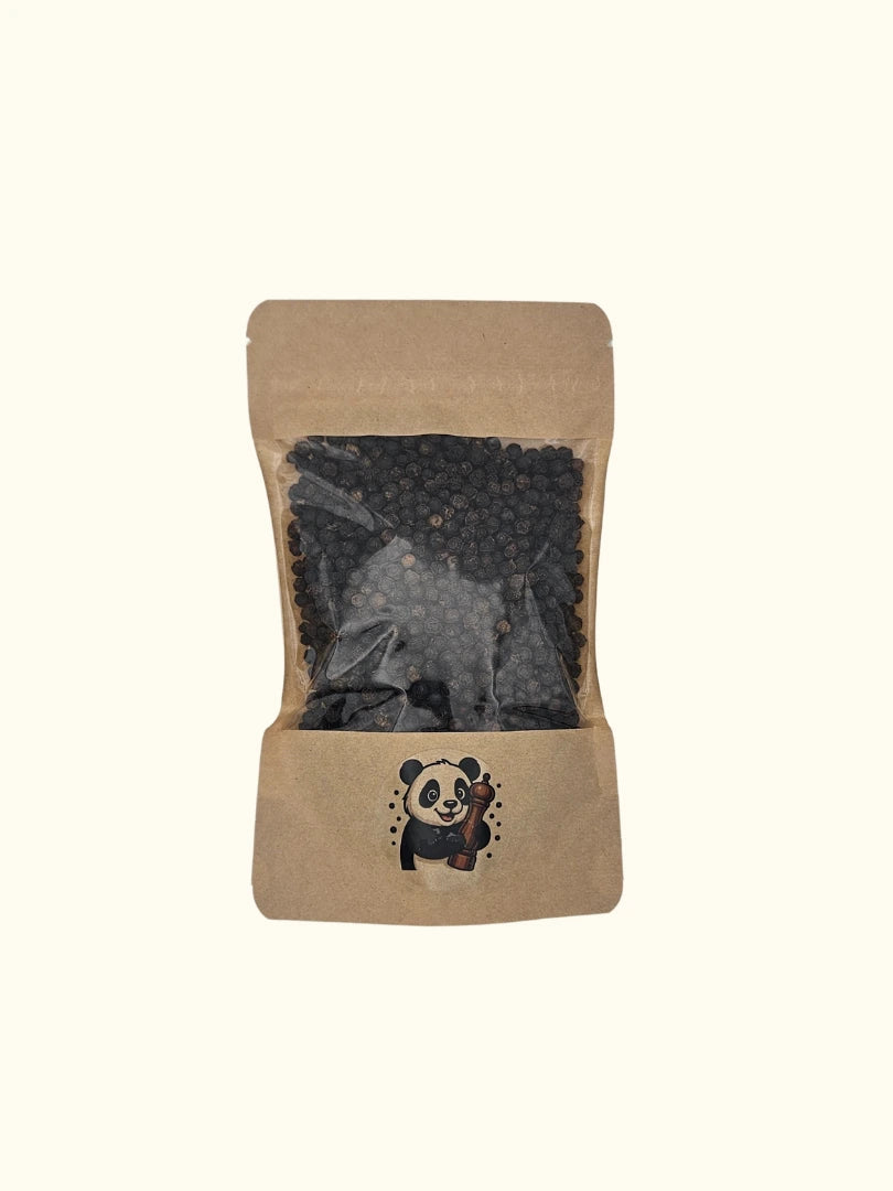 Ganze schwarze Pfefferkörner in einem nachhaltigen 100g Kraftpapier-Beutel mit Sichtfenster; das aromatische Gewürz von Pandiswelt zeigt ein Panda-Motiv mit Pfeffermühle, ideal zum frischen Mahlen beim Kochen und Grillen
