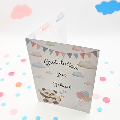 Schräg stehende Klappkarte zur Geburt; das Design zeigt Wimpelketten, Wolken und den Schriftzug „Gratulation zur Geburt“ in einer modernen, verspielten Schriftart
