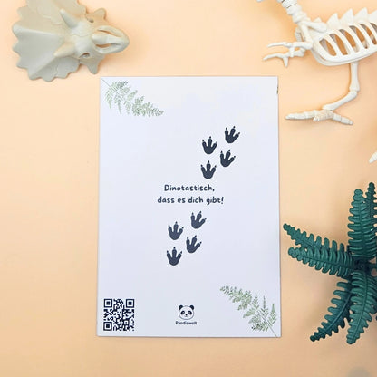 Rückseite der Karte mit dem Wortspiel „Dinotastisch, dass es dich gibt!“, Dino-Fußabdrücken und dem Pandiswelt-Markenlogo
