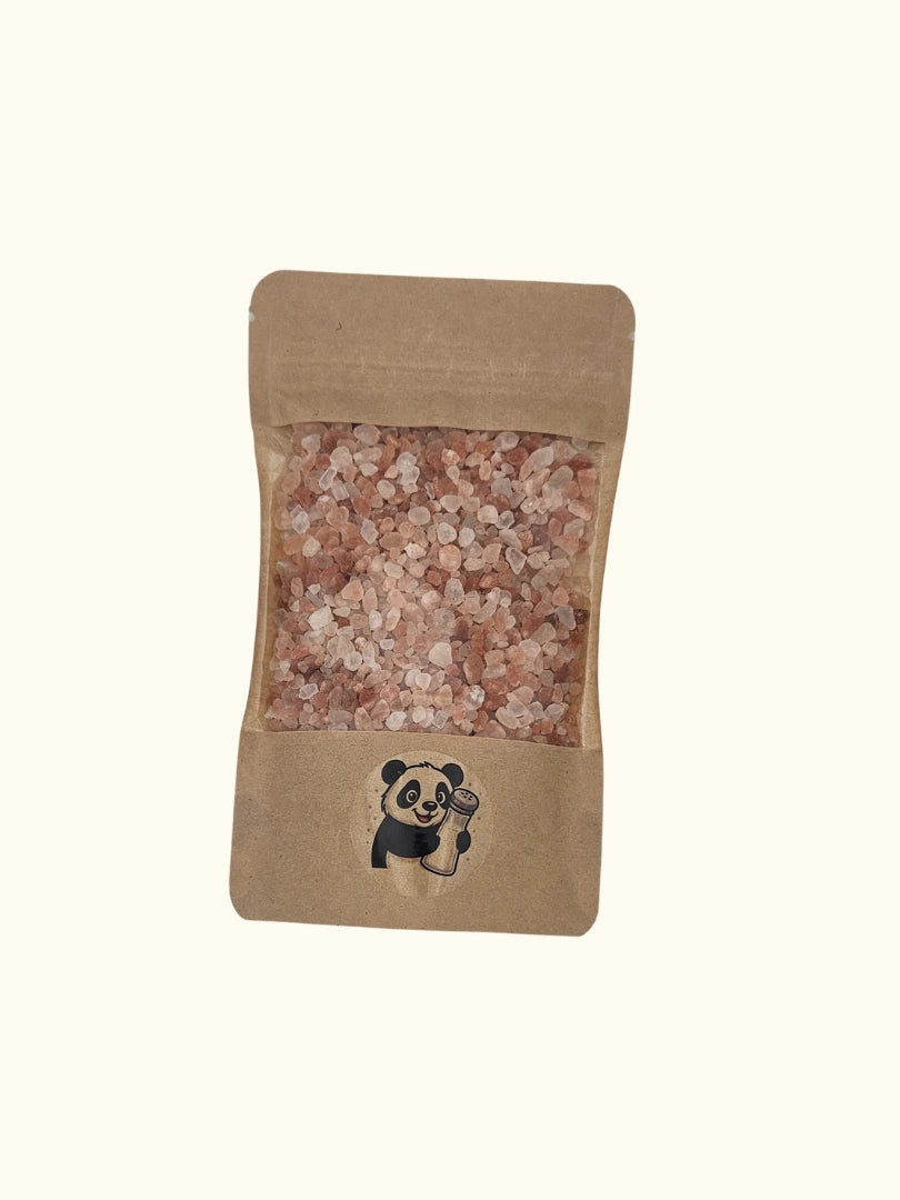 Grobes rosa Himalaya Salz in einer 215g Kraftpapier-Verpackung mit Sichtfenster; das natürliche Kristallsalz von Pandiswelt zeigt die charakteristische rosa Färbung, ideal als Gourmetsalz für die Salzmühle