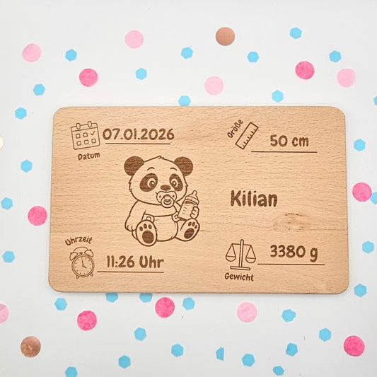 Detailansicht der personalisierten Holz-Geburtstafel mit niedlicher Panda-Grafik und individuellen Angaben zu Datum, Uhrzeit, Größe und Gewicht; ein langlebiges Erinnerungsgeschenk aus Buchenholz, flach liegend auf buntem Konfetti