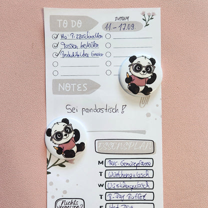 Ein Panda-Magnet mit Brille und Stift fixiert einen beispielhaften Essensplan und eine To-Do-Liste; ideal zur Organisation von Terminen und Wochenplänen am Kühlschrank oder einer Magnettafel