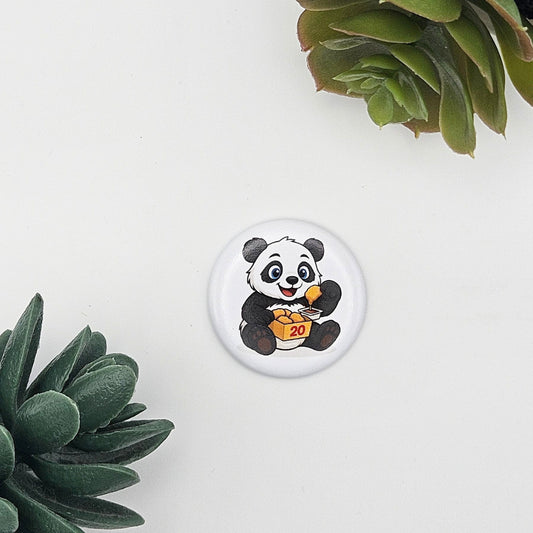 Runder Kühlschrankmagnet (Ø 3,8 cm) mit einem niedlichen Panda, der Chicken Nuggets aus einer 20er-Box isst; humorvolle Geschenkidee für Foodies und Panda-Fans, präsentiert auf weißem Hintergrund mit Sukkulenten
