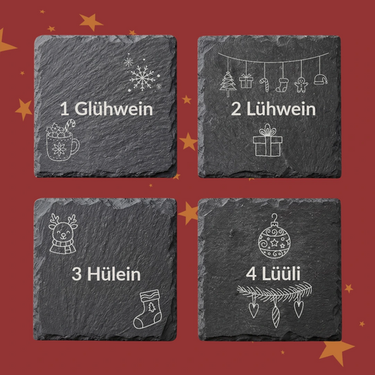 Vier Schieferuntersetzer mit den Gravuren 1 Glühwein, 2 Lühwein, 3 Hülein und 4 Lüüli, jeweils mit Weihnachtsmotiven wie Schneeflocke, Rentier und Christbaumkugel