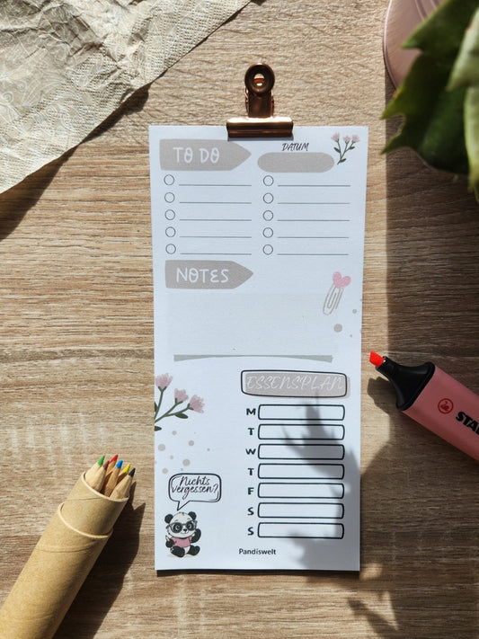Kompakter Mini-Wochenplaner von Pandiswelt mit integrierter To-Do-Liste, Notizfeld und Essensplan; das Design zeigt einen Panda mit Brille und den motivierenden Schriftzug „Sei pandastisch!“, flach liegend auf Holz mit Stiften