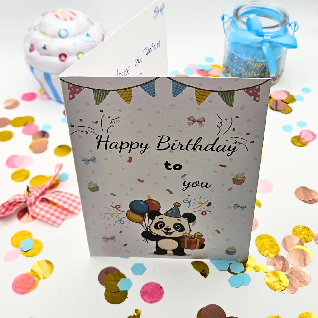 Liebevoll gestaltete Panda-Geburtstagskarte im A6-Format mit dem Schriftzug „Happy Birthday to you“; das Motiv zeigt einen Panda mit Luftballons und Geschenk inmitten von bunter Konfetti-Dekoration