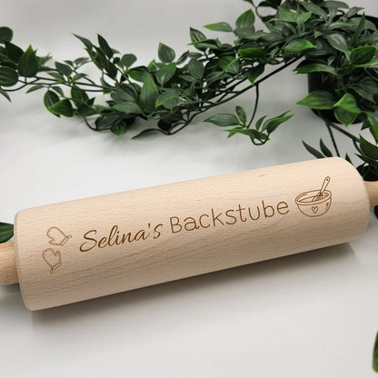 Nahaufnahme der Gravur Selinas Backstube mit Ofenhandschuhen und Rührschüssel auf dem Nudelholz