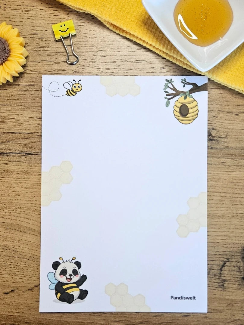 Einzelner Notizblock A5 von Pandiswelt mit 25 Blatt und hochwertigem Farbdruck eines Pandas im Bienenkostüm; ein fröhlicher Briefblock für Notizen, präsentiert auf Holz mit einem gelben Motiv-Clip