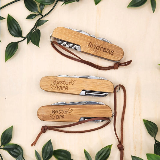 Auswahl an Personalisierungsmöglichkeiten für das Taschenmesser mit Bambus-Griff, gezeigt mit verschiedenen Gravuren wie Namen oder Widmungen für Papa und Opa
