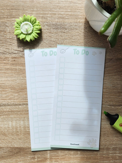 Darstellung zweier mintgrüner To-Do-Listen Blöcke von Pandiswelt mit Checkboxen und Pfoten-Motiv; dekorative Präsentation auf Holz mit passendem grünem Textmarker und Blumenkerze zur täglichen Organisation