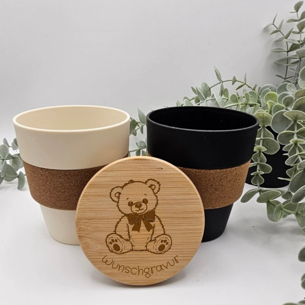 Personalisierte To-Go Becher mit Teddybär Motiv und einer Wunschgravur für den Namen auf einem Bambusdeckel.