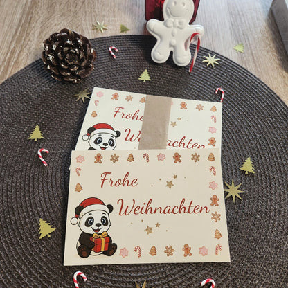 Detailansicht der hochwertigen Panda-Postkarte; die Abbildung zeigt die Karte präsentiert mit einer dekorativen Papierbanderole in einem weihnachtlichen Ambiente mit Zuckerstangen